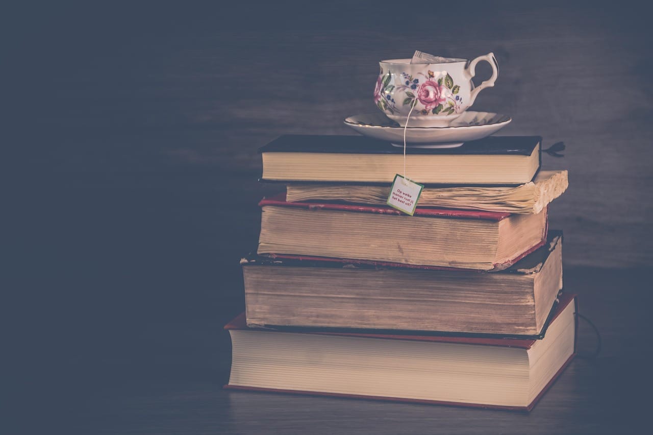 Her cup, on the three books she was two-thirds through.